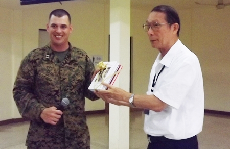 Chaplain Barrett Craig (left), Combat Logistics Battalion 31 accepts souvenir books from Father Veera Phangrak, director of the Pattaya Orphanage.